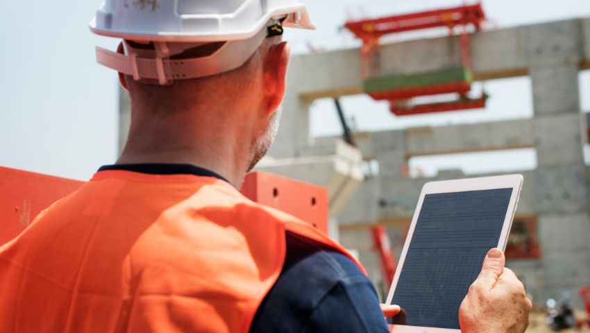 Immagine di operaio che utilizza le tecnologie nel cantiere.